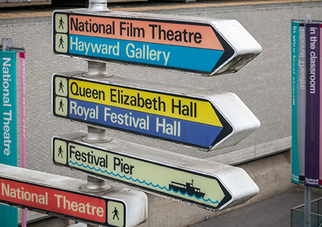 A street sign pointing to the vibrant iconic London landmarks.