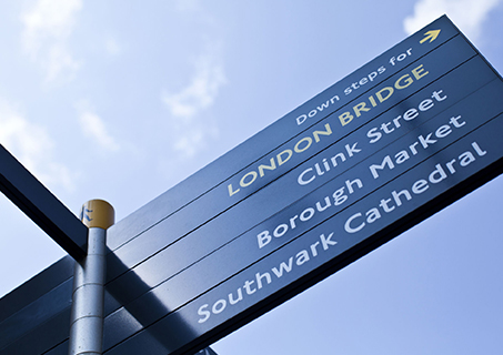 A street sign pointing to the vibrant iconic London landmarks.