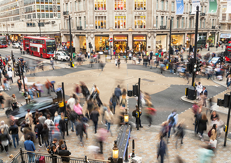 A vibrant image of the bustling streets of Oxford Circus, showcasing shoppers and iconic stores.